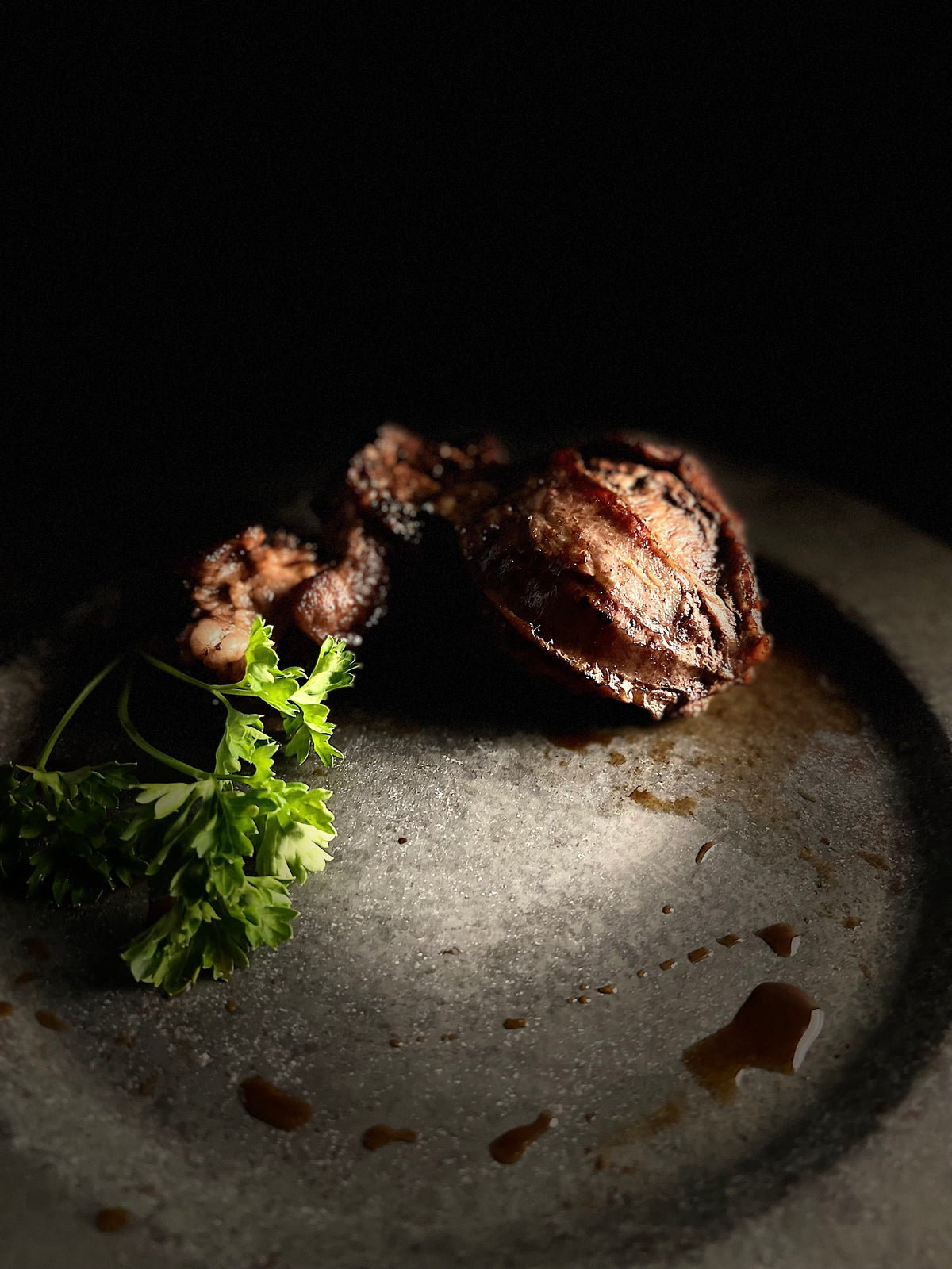 Cooked cheek meat and garnish on round plate